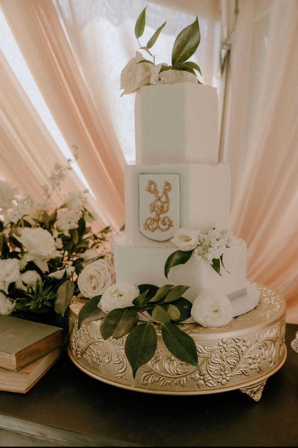 White Hexagon with Gold Monogram and white floral wedding cake